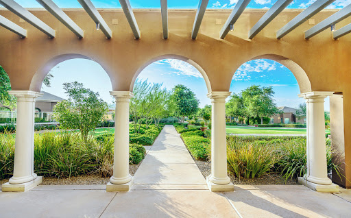 A serene view of a landscaped garden framed by elegant arches under a clear blue sky.