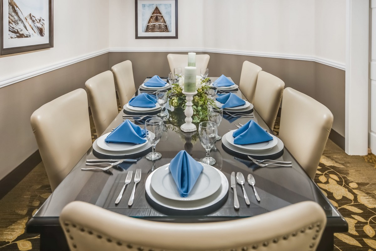 A formal dining setup with blue napkins and elegant cutlery.