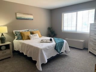 A cozy and modern bedroom with a neatly made bed and minimalist decor.