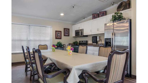 A spacious dining area featuring a large table and modern kitchen appliances.