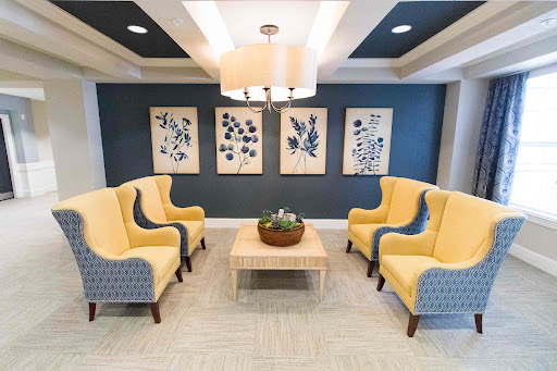 A cozy lounge area featuring modern yellow chairs and botanical artwork.