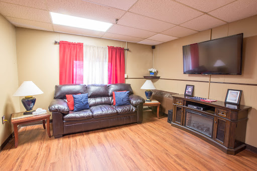 A cozy living room featuring a leather sofa, vibrant curtains, and an entertainment setup.