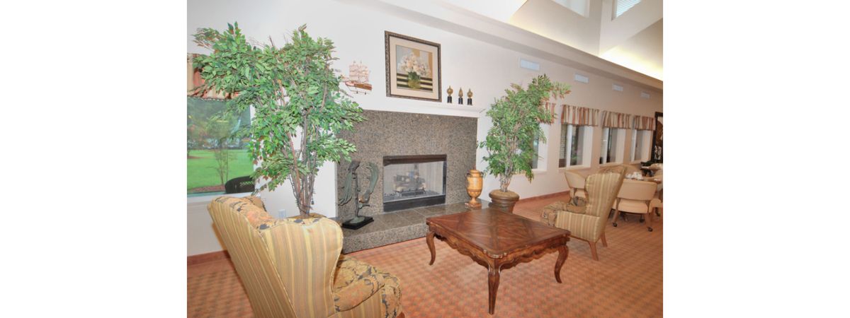 A cozy living room featuring a fireplace, decorative plants, and elegant furniture.
