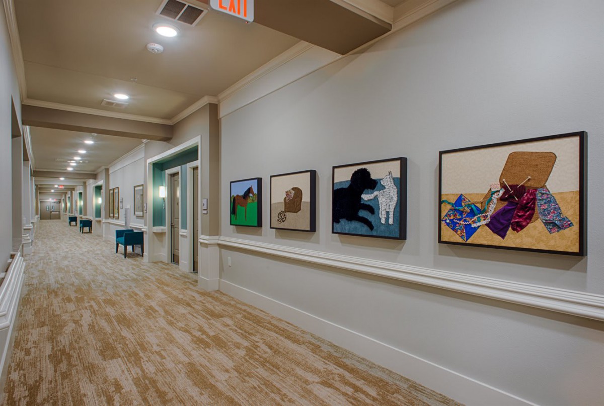 A hallway lined with modern art paintings on display.