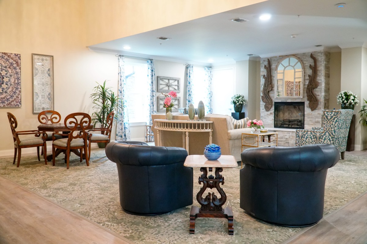 A cozy living room with stylish furniture, featuring a fireplace and decorative accents.
