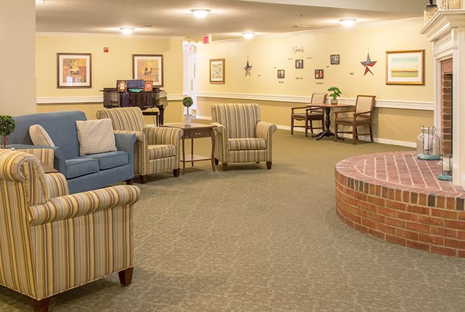 A cozy seating area with comfortable chairs and a sofa in a warmly lit lobby.