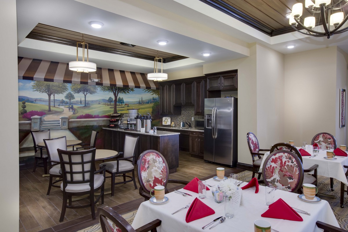 A beautifully arranged dining area with elegant furniture and a modern kitchen backdrop.