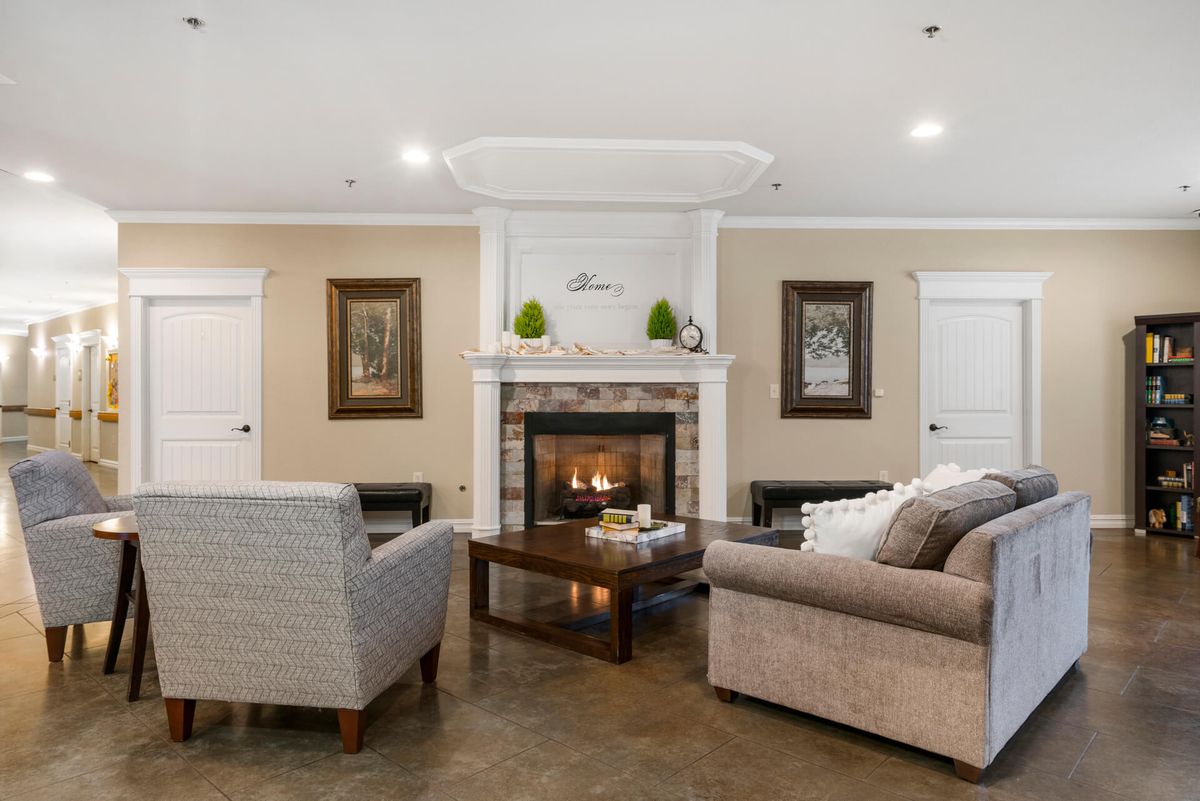 A cozy living room with a central fireplace surrounded by comfortable seating and tasteful decor.