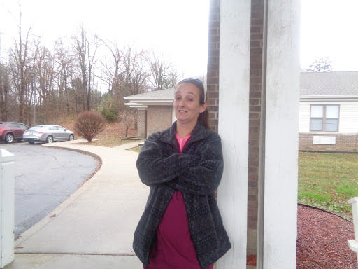 A person enjoying a moment outside, casually leaning against a pillar.