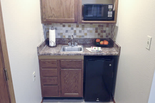 Cozy kitchenette with a microwave, mini fridge, and sink.