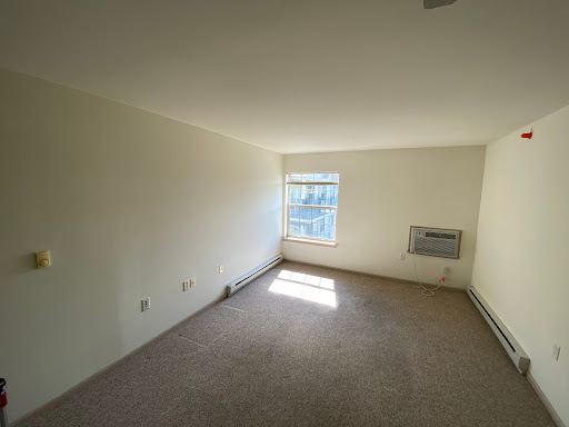 A bright and empty room with a window allowing natural light, ready for new furnishings.