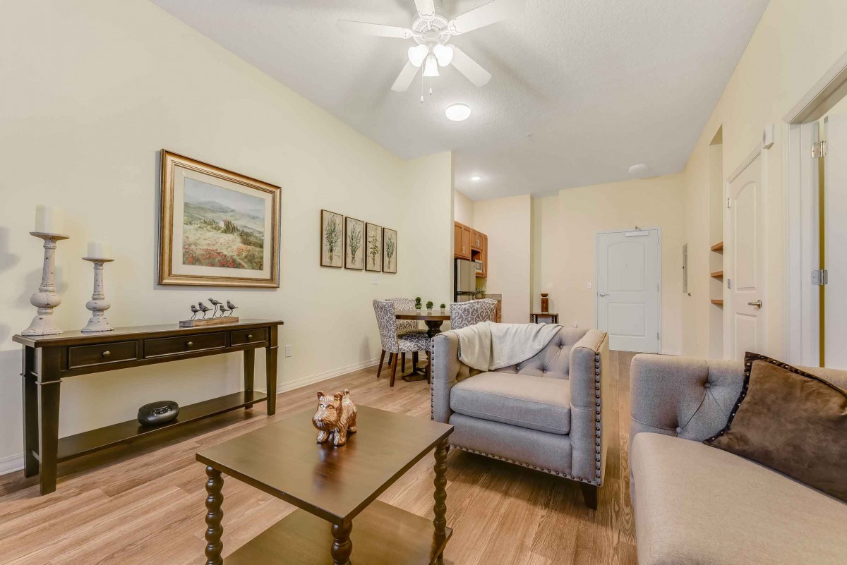 A cozy living room with modern furniture and decor, featuring a sofa and coffee table on a hardwood floor.