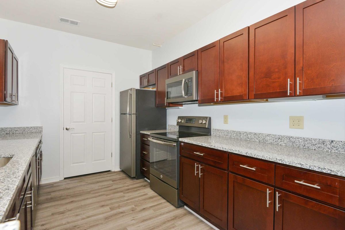 A modern kitchen with stainless steel appliances and wood cabinetry.