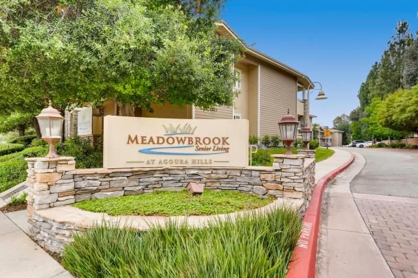 Entrance to Meadowbrook Apartments with landscaped surroundings.
