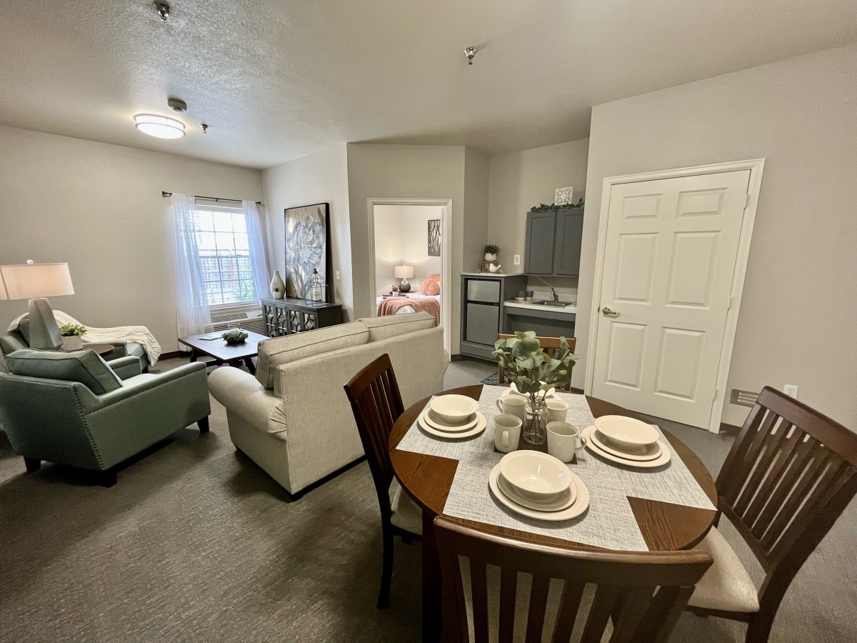 A modern apartment interior featuring an open living and dining area with stylish furniture.