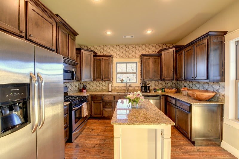 A modern kitchen with wooden cabinets, stainless steel appliances, and a central island.