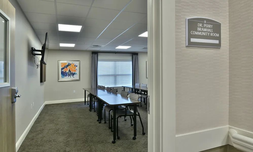 An empty conference room with tables and chairs arranged for a meeting.