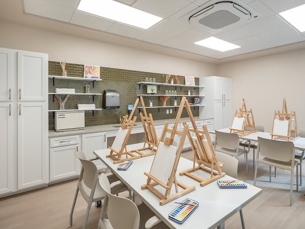 A well-equipped art studio with easels set up for painting.