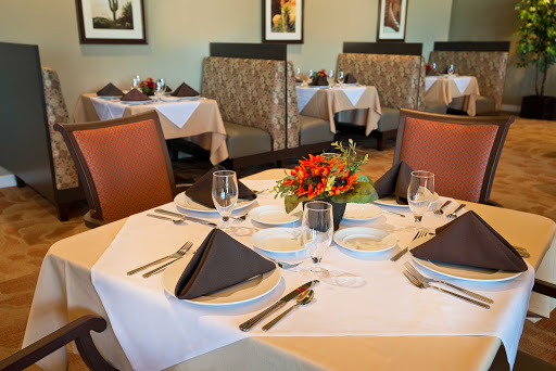 An elegantly set dining table in a modern restaurant, featuring tasteful decor and floral arrangements.