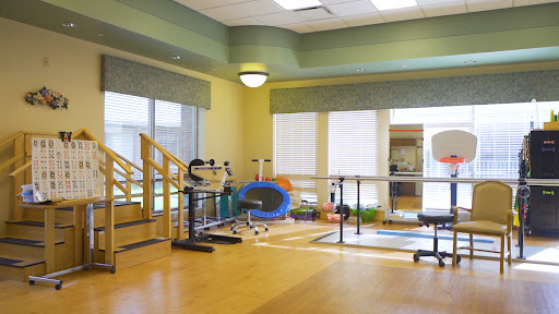 A well-lit physical therapy room equipped with various exercise tools for rehabilitation.