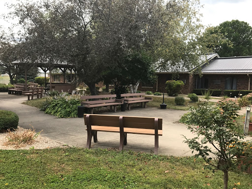 A serene outdoor space featuring benches surrounded by greenery.