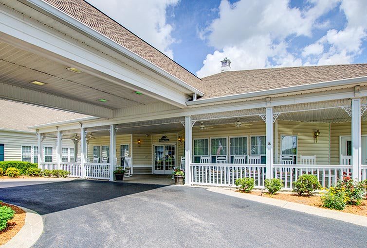 A building entrance with a covered driveway and large porch.