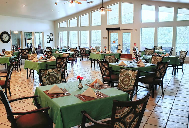 A well-lit restaurant dining area with neatly arranged tables and chairs.