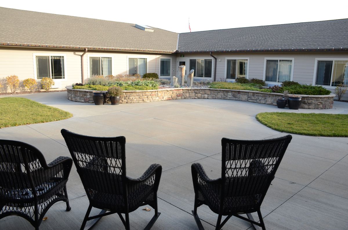 A serene courtyard with two chairs and a landscaped view.