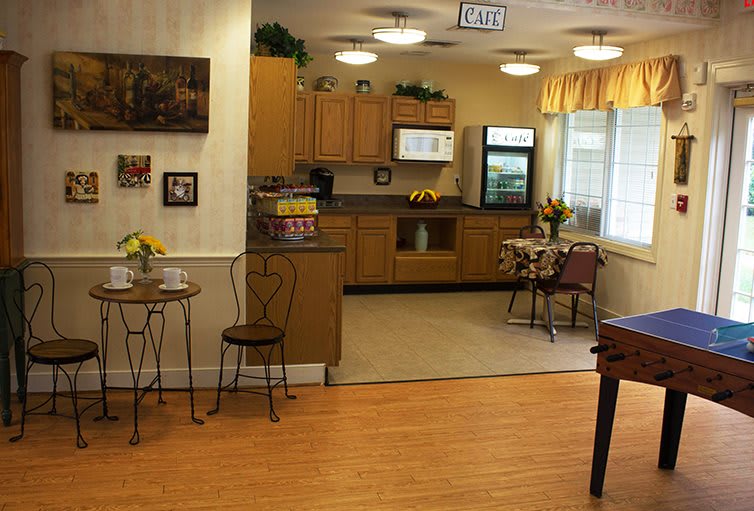 A cozy kitchen and dining area with wooden cabinets and a small dining table, featuring homey decor.