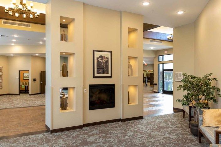 A modern living room featuring a central fireplace and decorative shelving.