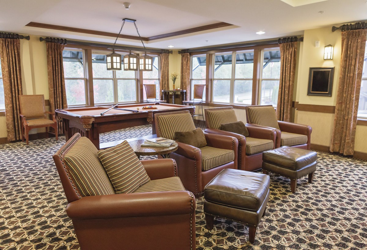 A cozy lounge area with comfortable armchairs and a pool table.