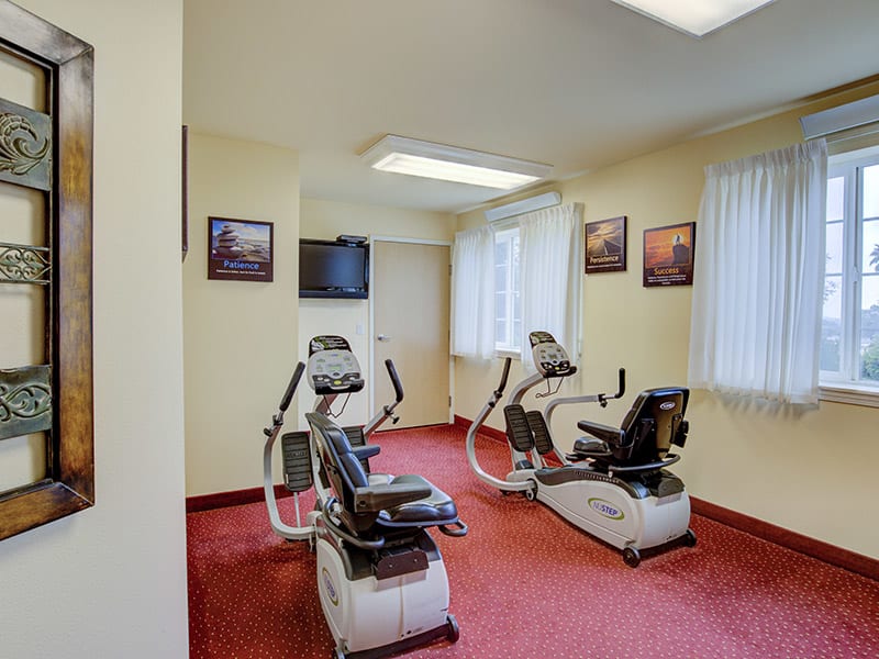 A small workout area with stationary bikes and a television.