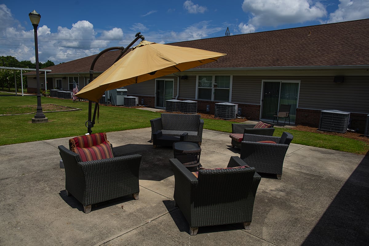 Outdoor patio setup with chairs and an umbrella on a sunny day.