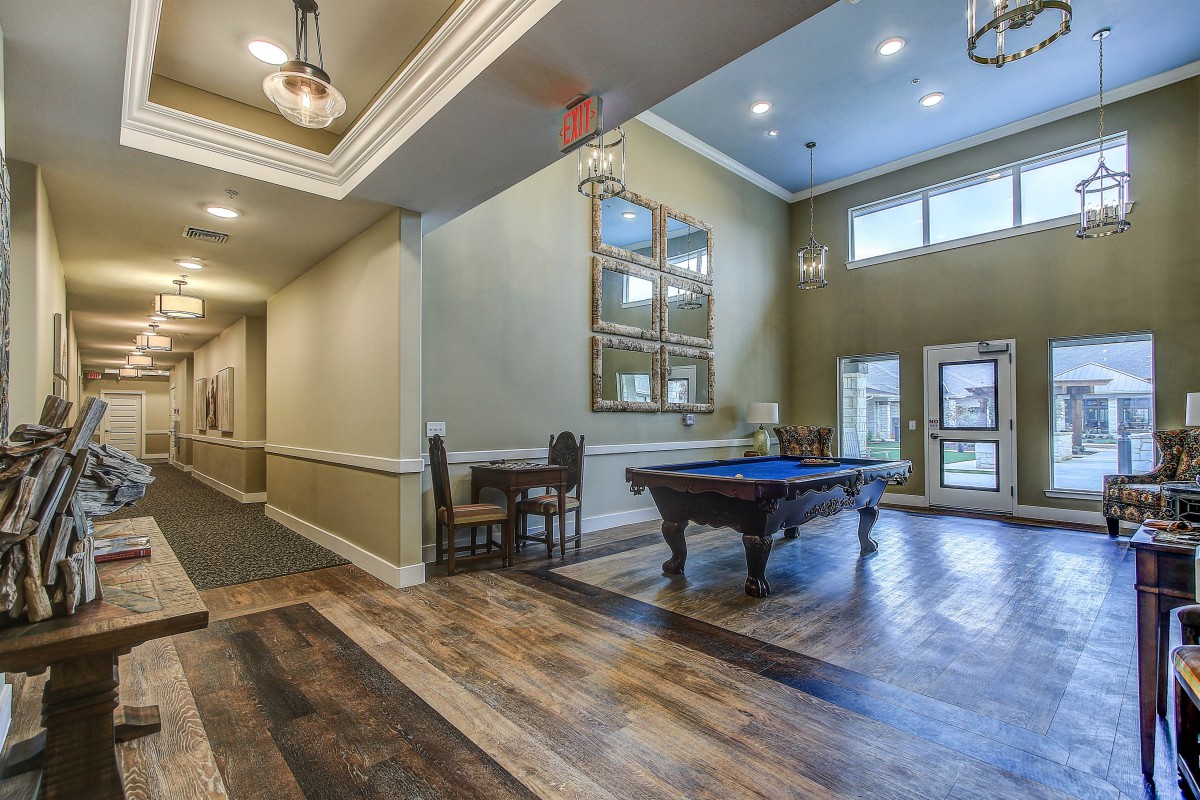 A modern interior space featuring a pool table and elegant lighting.