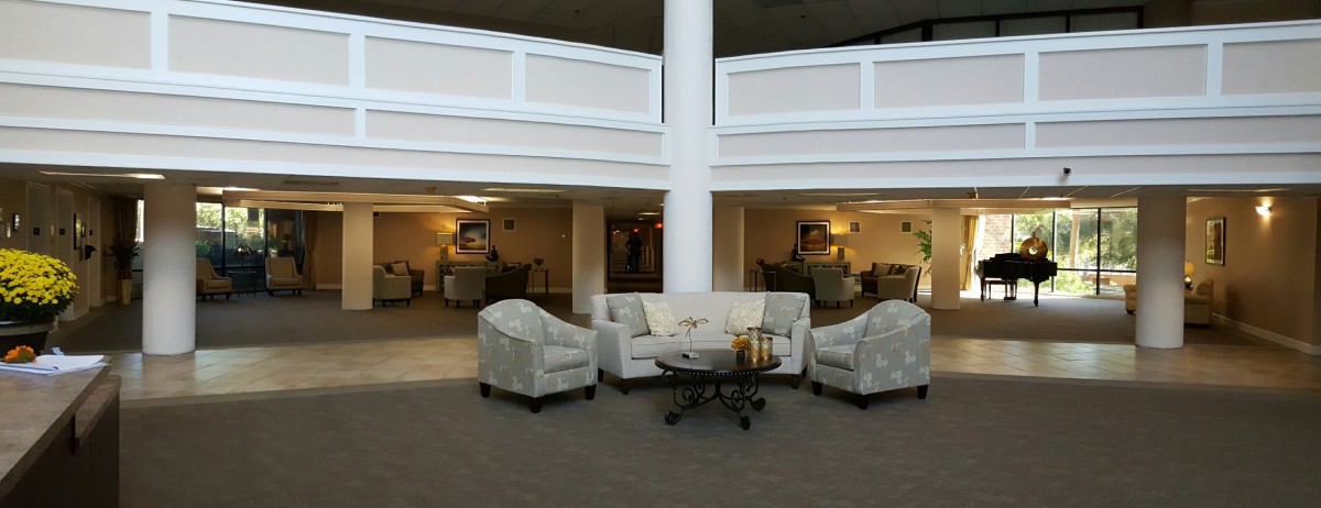 A modern lobby seating area with a sofa, chairs, and a coffee table.