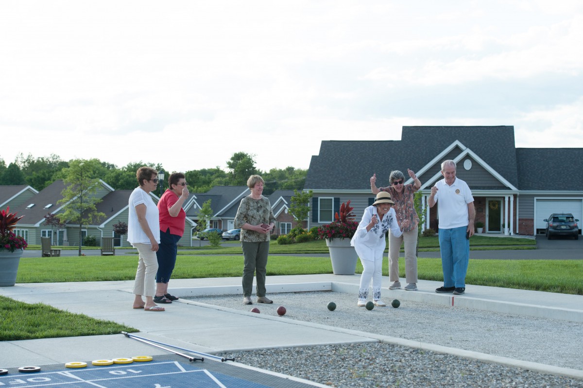 A group of seniors playing bocce ball in a community setting.