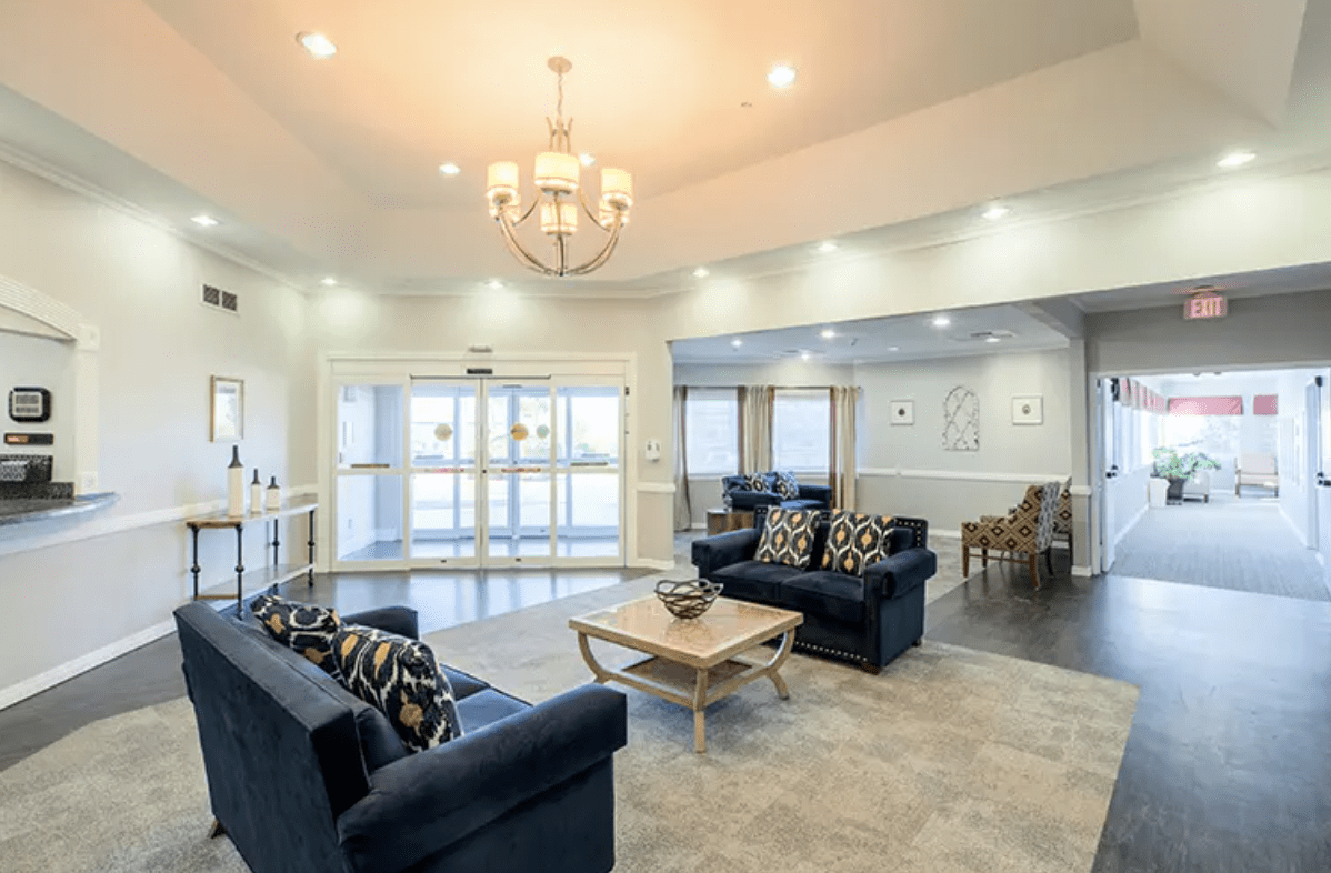 A modern living room with blue sofas and a chandelier.