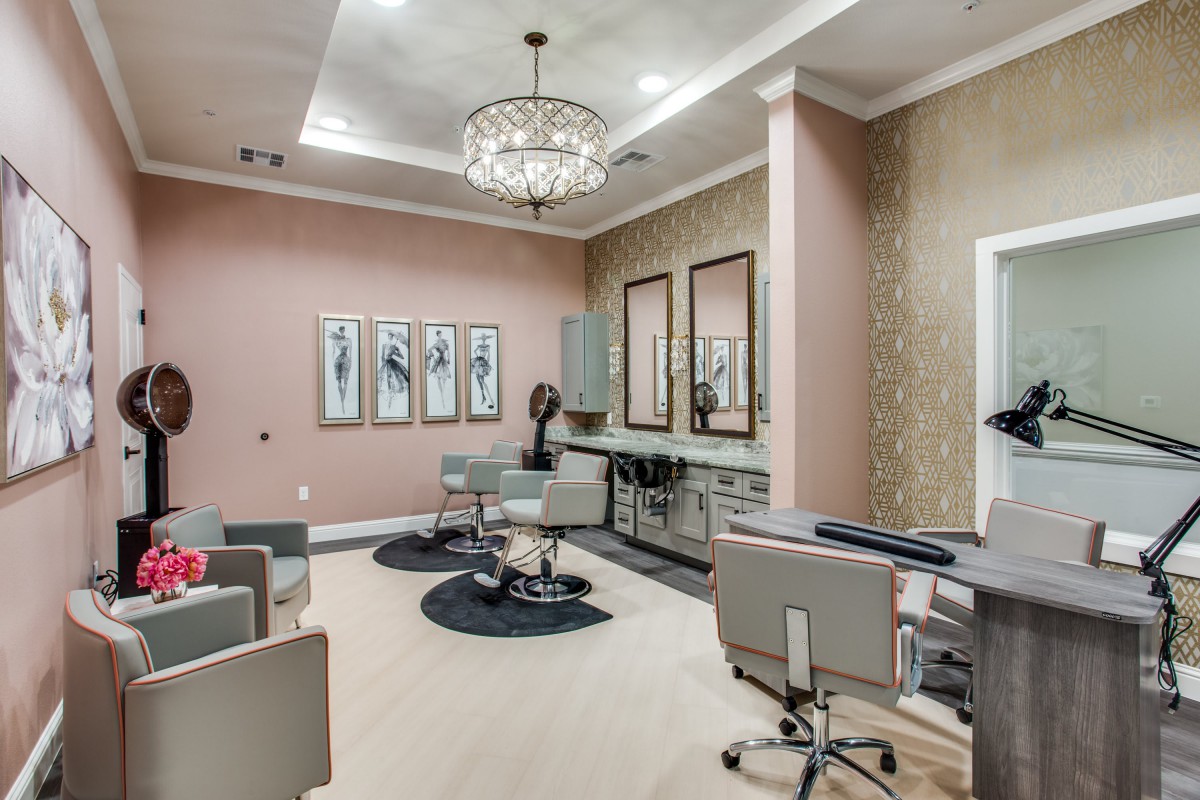 A modern and elegant salon interior with plush seating, chandeliers, and stylish artwork.