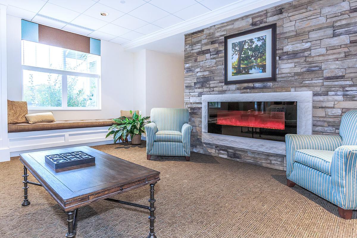 A cozy living room with a fireplace, armchair, and coffee table.