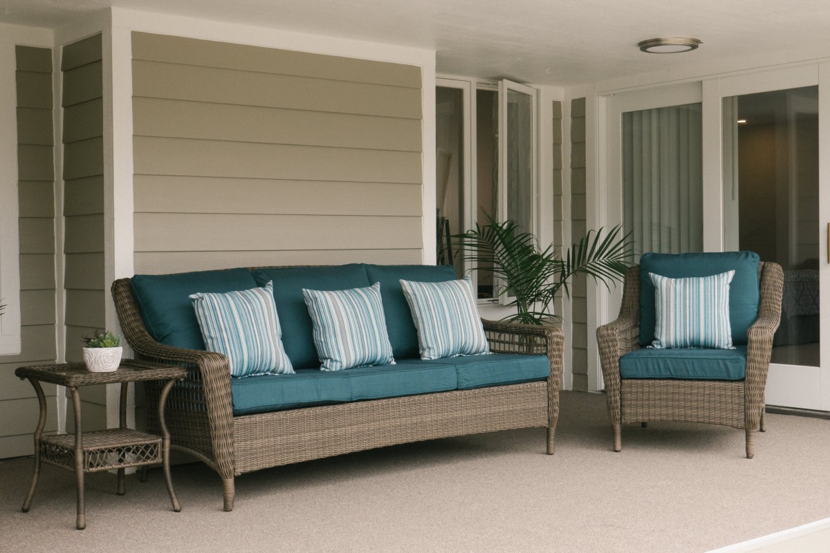 Outdoor patio area with wicker furniture and blue cushions.