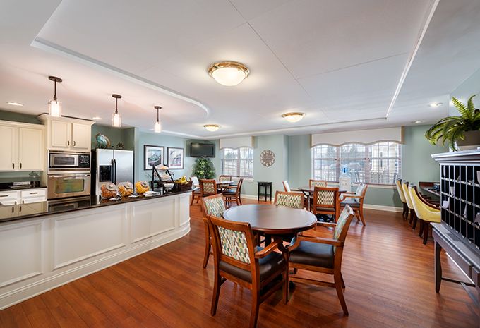 A bright and spacious dining area connected to a modern kitchen with hardwood floors and elegant lighting.