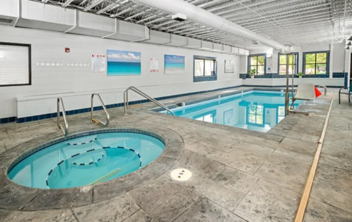 An indoor recreational area featuring a swimming pool and hot tub.
