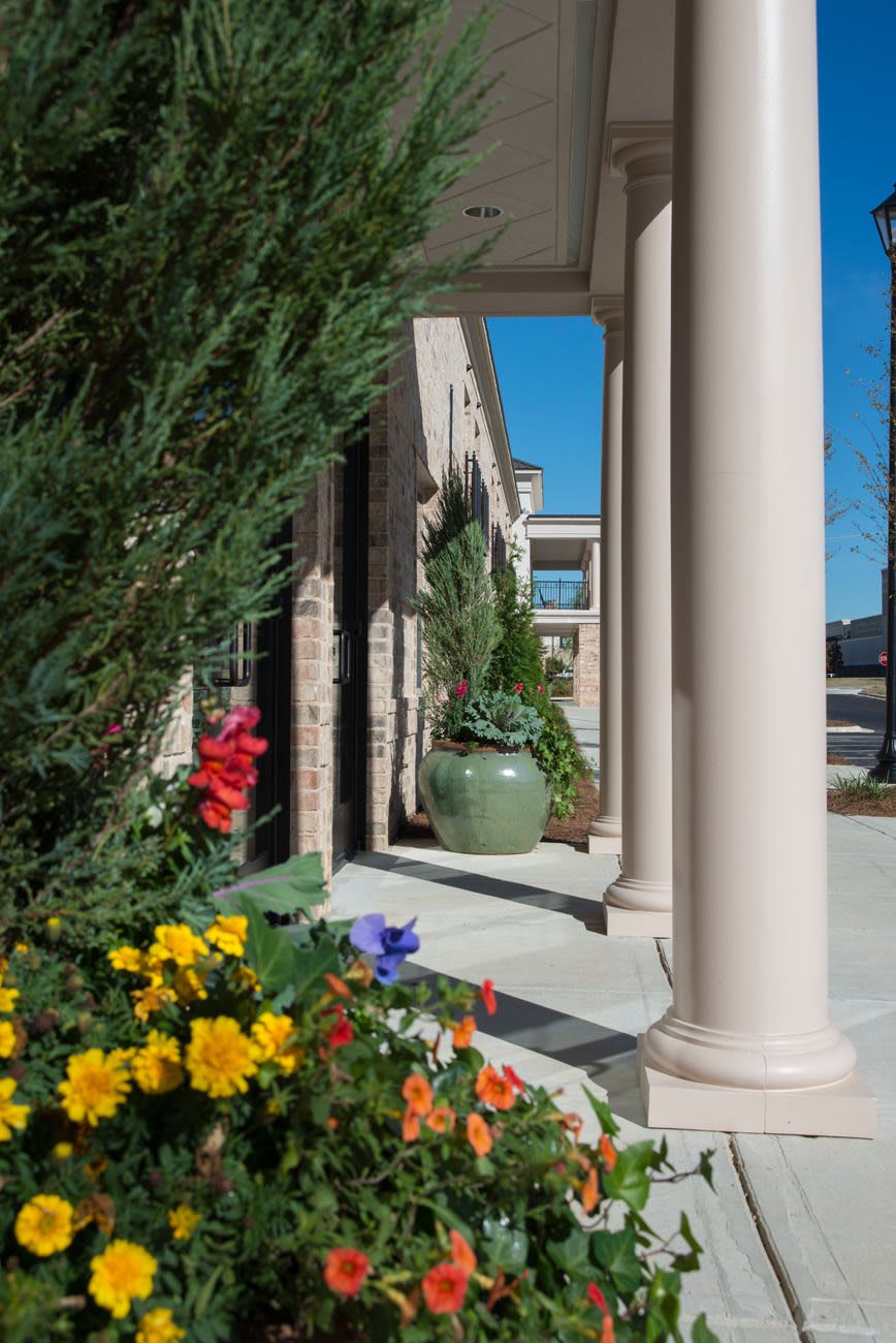A sunny day with colorful flowers and architectural columns in view.