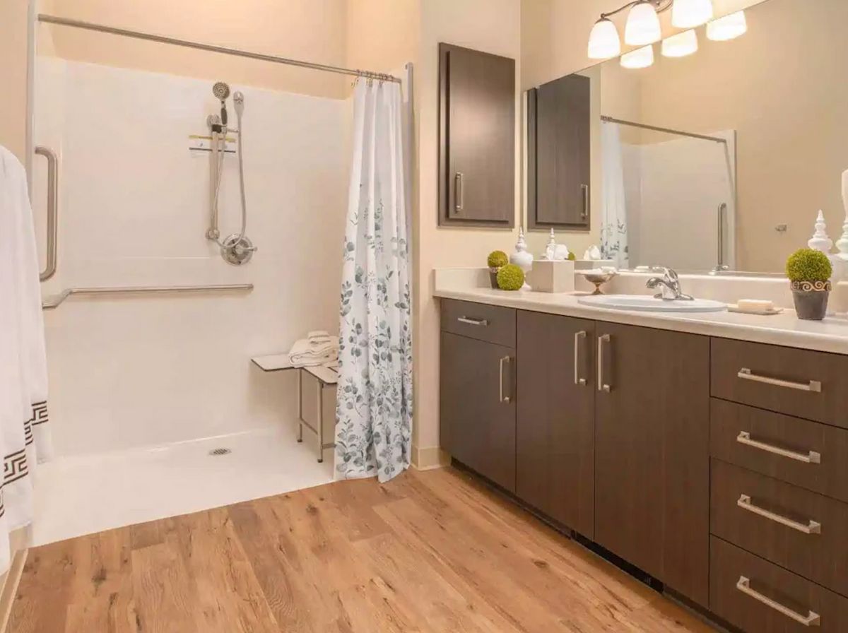 A modern bathroom with a walk-in shower and a large vanity with double sinks.