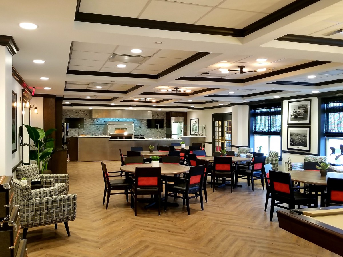 A modern dining area with wooden floors and elegant ceiling lighting.
