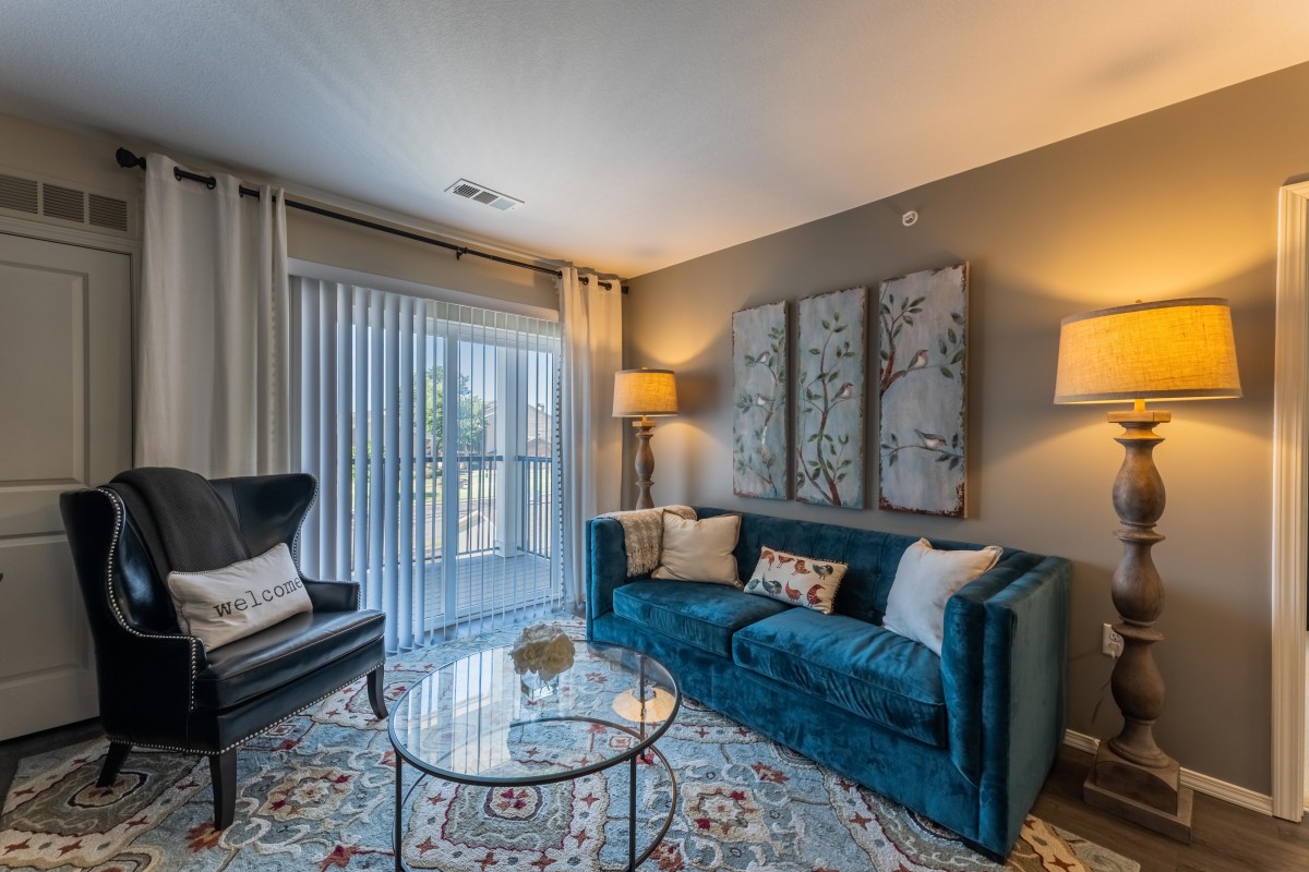 A cozy living room with a stylish blue sofa, modern armchair, and elegant decor.