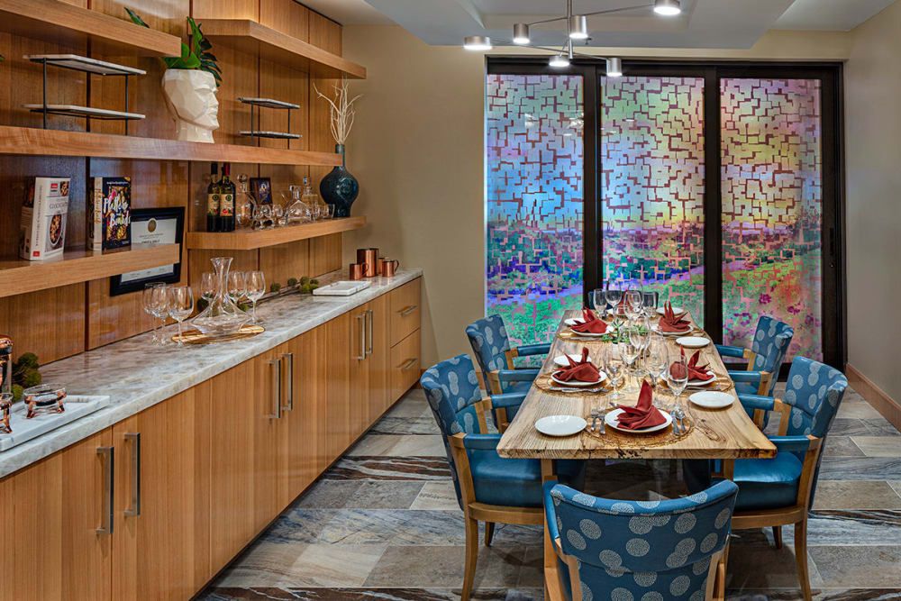 A beautifully set modern dining room with colorful chairs and elegant decor.