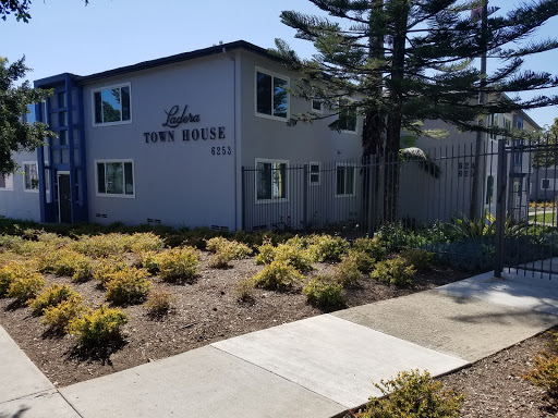 A view of the exterior of an apartment building with landscaped grounds.