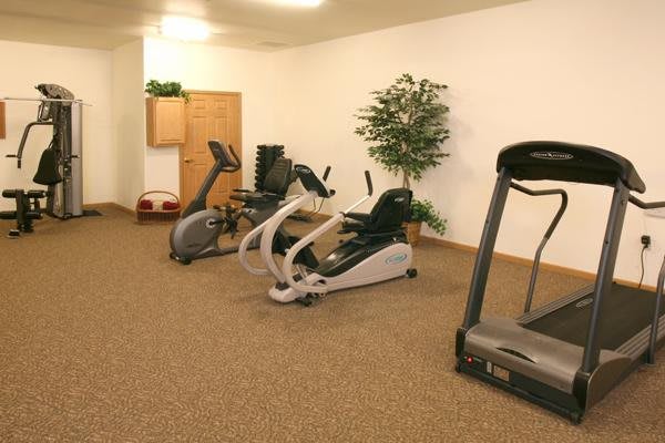 A small indoor gym with various exercise equipment, including a treadmill and stationary bike.