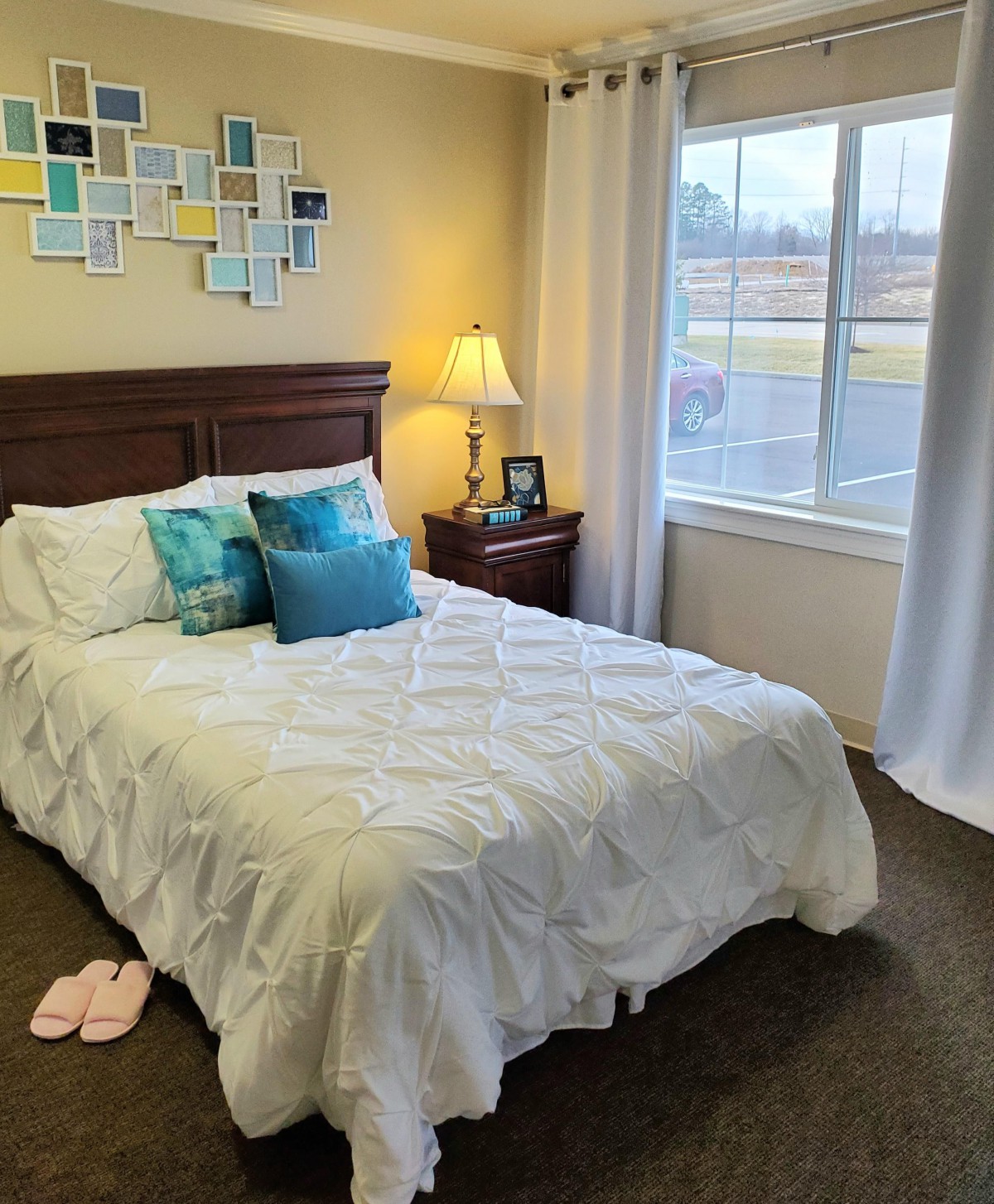 A cozy bedroom with a neatly made bed and decorative pillows.